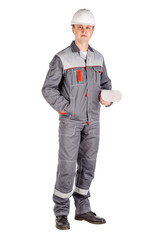 Full length portrait of a male builder in a helmet looking at camera over white wall background. repair, construction, building, people and maintenance concept.