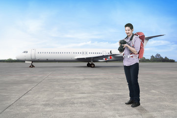 Young asian man with backpack and camera going traveling