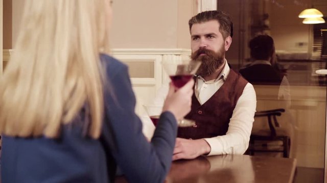 Couple in love. Handsome man flirting with cute woman in restaurant. Bearded man flirting with young sexy blonde