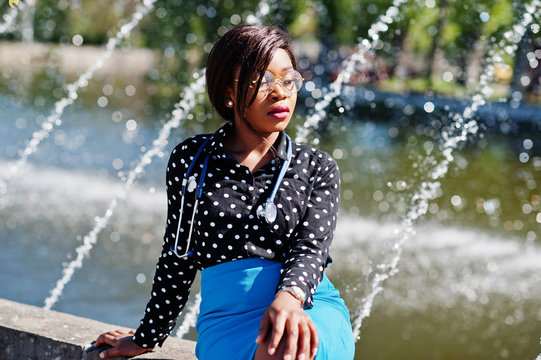 African american doctor female with stethoscope posed outdoor background fountains.