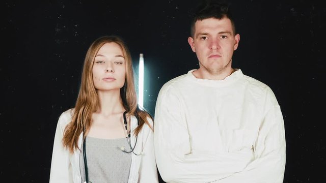 Psychiatric hospital. Mentally ill patient in straitjacket and doctor.