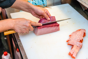 Japanese chef using knife cut the raw fish
