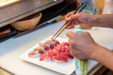 Japanese chef arrange sushi on the plate
