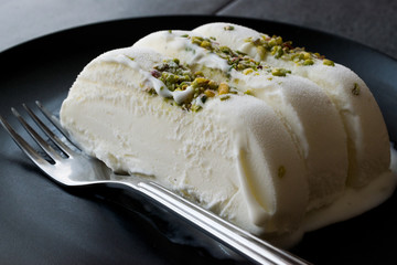 Turkish Maras Vanilla Ice Cream with Pistachio Powder Served Portion in Black Plate.