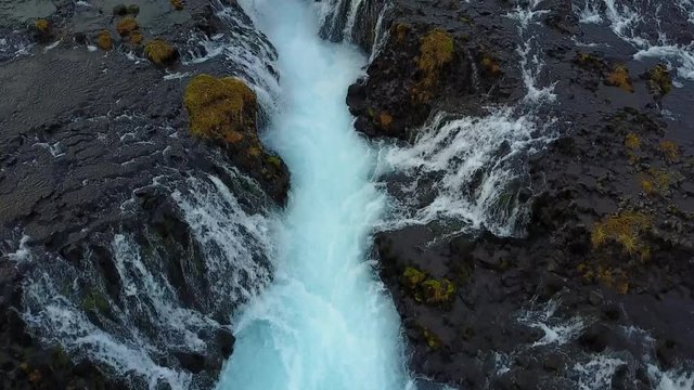 4K. Aerial view over Bruarfoss waterfall. Flowing of turquoise water and surrounded by fresh snow of winter. famous destination in South Iceland