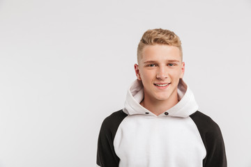 Portrait closeup of teenage boy 16-18 years old wearing hoodie looking at camera with happy smile,...
