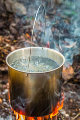 Water boiling in a camping pot on a folding hiking stove