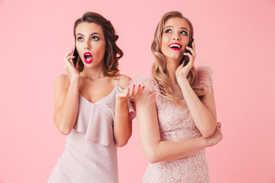 Two young elegant women in dresses posing together