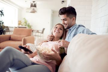 Couple watching TV and eating popcorn