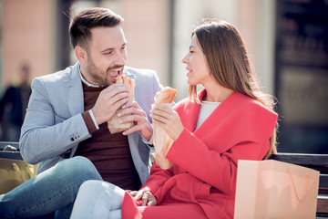 Couple eating sandwiches after shopping