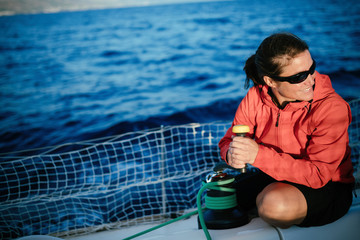 Attractive strong woman sailing with her boat