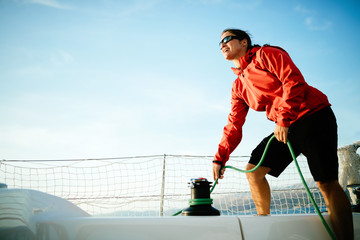 Attractive strong woman sailing with her boat