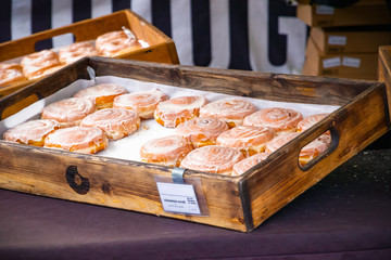 Selective focus, fresh cinnamon scrolls on display at Kings Cross outdoor food market in London