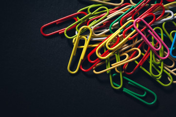 Paper clips multi-coloured on a dark  background