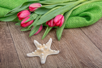 Concept of starfish and tulips on a table