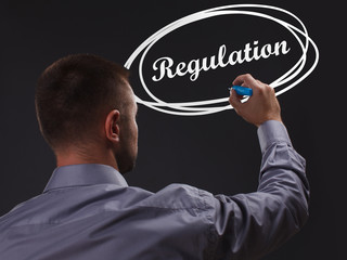 The concept of business, technology, the Internet and the network. Young businessman showing inscription: Regulation