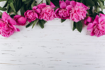 Pink and white peonies on a wooden background. Copy space and flat lay.