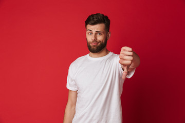 Sad young man showing thumbs down