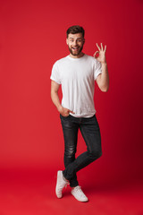 Handsome happy young man showing okay gesture.