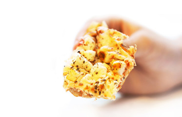 Piece of pizza in hand close-up isolated on white background