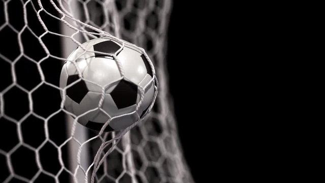 Beautiful soccer ball flies into net on a black background. In slow motion