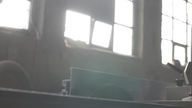 Light coming for windows in carpentry workshop and saw starting to rotate 