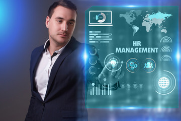 Business, Technology, Internet and network concept. Young businessman working on a virtual screen of the future and sees the inscription: HR management