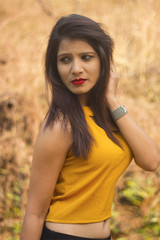 Fototapeta premium Stylish and beautiful woman with long brown hair wearing yellow blouse looking sideways