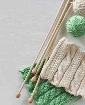 Two bright patterns and wooden knitting needles for a white background