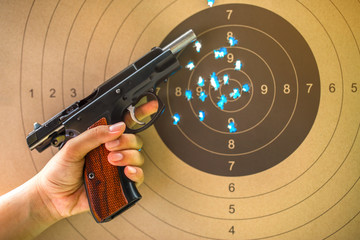 9 mm hand gun on bullseye target for shooting practice.