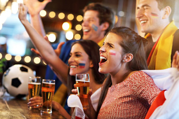 Group of friends watching soccer in pub