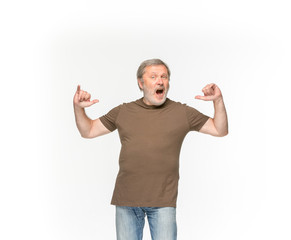 Naklejka premium Closeup of senior man's body in empty brown t-shirt isolated on white background. Mock up for disign concept