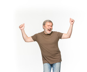 Closeup of senior man's body in empty brown t-shirt isolated on white background. Mock up for disign concept