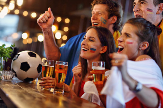 Group of friends watching soccer in pub