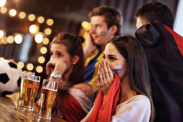 Group of friends watching soccer in pub