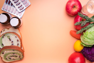 Naklejka na ściany i meble healthy food fruit and vegetable against junk food and supplementary medicine on orange background