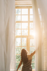 Good morning mood. Woman opening window. View from back. Sunny weekend