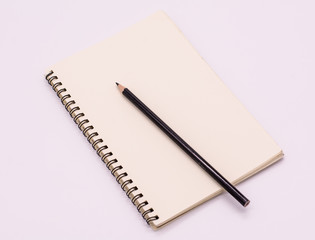 Notebook paper and black pencil on white background