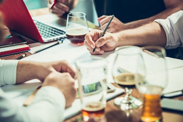 The hands of people working and relaxing in pub.