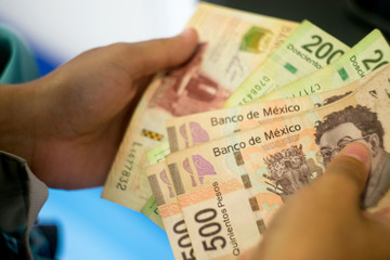 Hands counting Mexican money