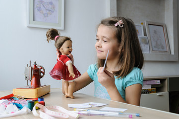 The girl is playing with a doll.
