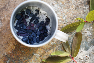 metal mug with honeysuckle berries