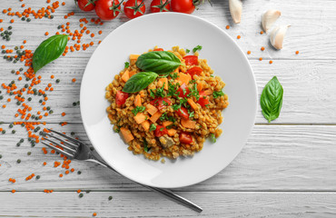 Plate with tasty lentil dish on table
