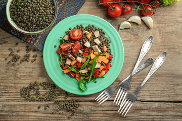 Plate with tasty lentil dish on table