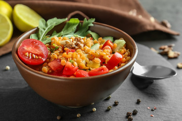 Bowl with delicious lentils salad on slate plate