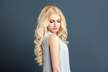 Naklejka premium Portrait of young model with beautiful hair on grey background