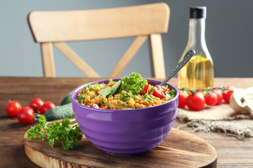 Bowl with delicious lentils salad on wooden table