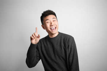 Portrait of young Asian man on light background