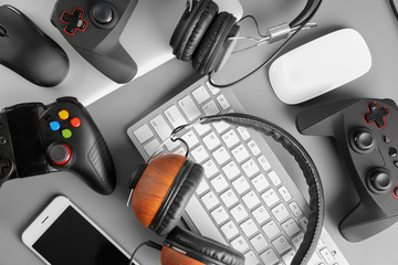 Gamepads, mice, headphones and keyboard on table