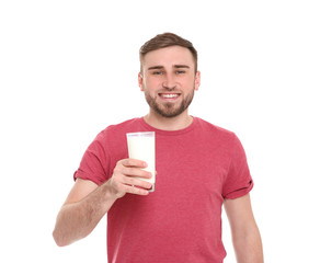 Young man with glass of tasty milk on white background